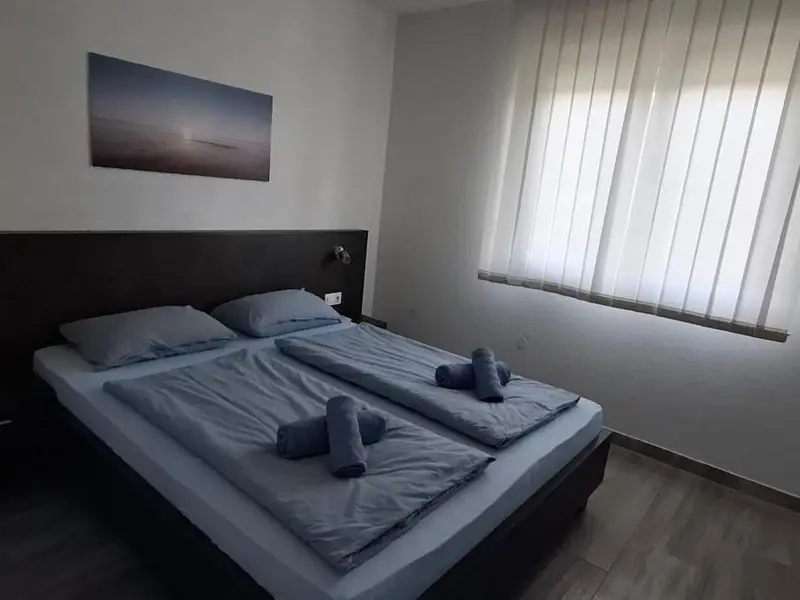 Spavaća soba s tamnim uzglavljem i plavom posteljinom